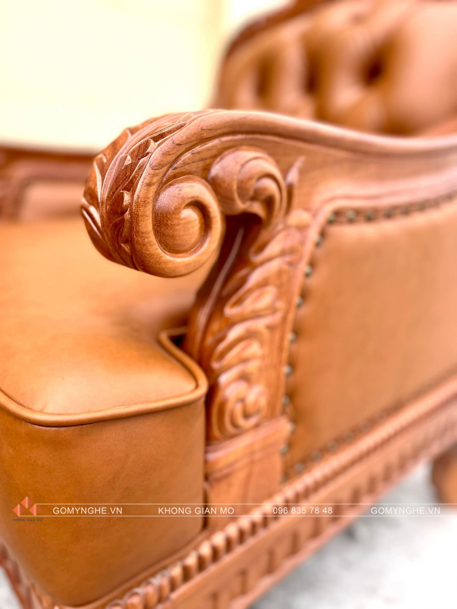 Bộ sofa tân cổ điển gỗ gõ đỏ bọc da Microfiber Pcarola, thiết kế chạm hoa văn đồng bộ, gồm sofa dài, ghế đơn và bàn trà, phù hợp phòng khách sang trọng.