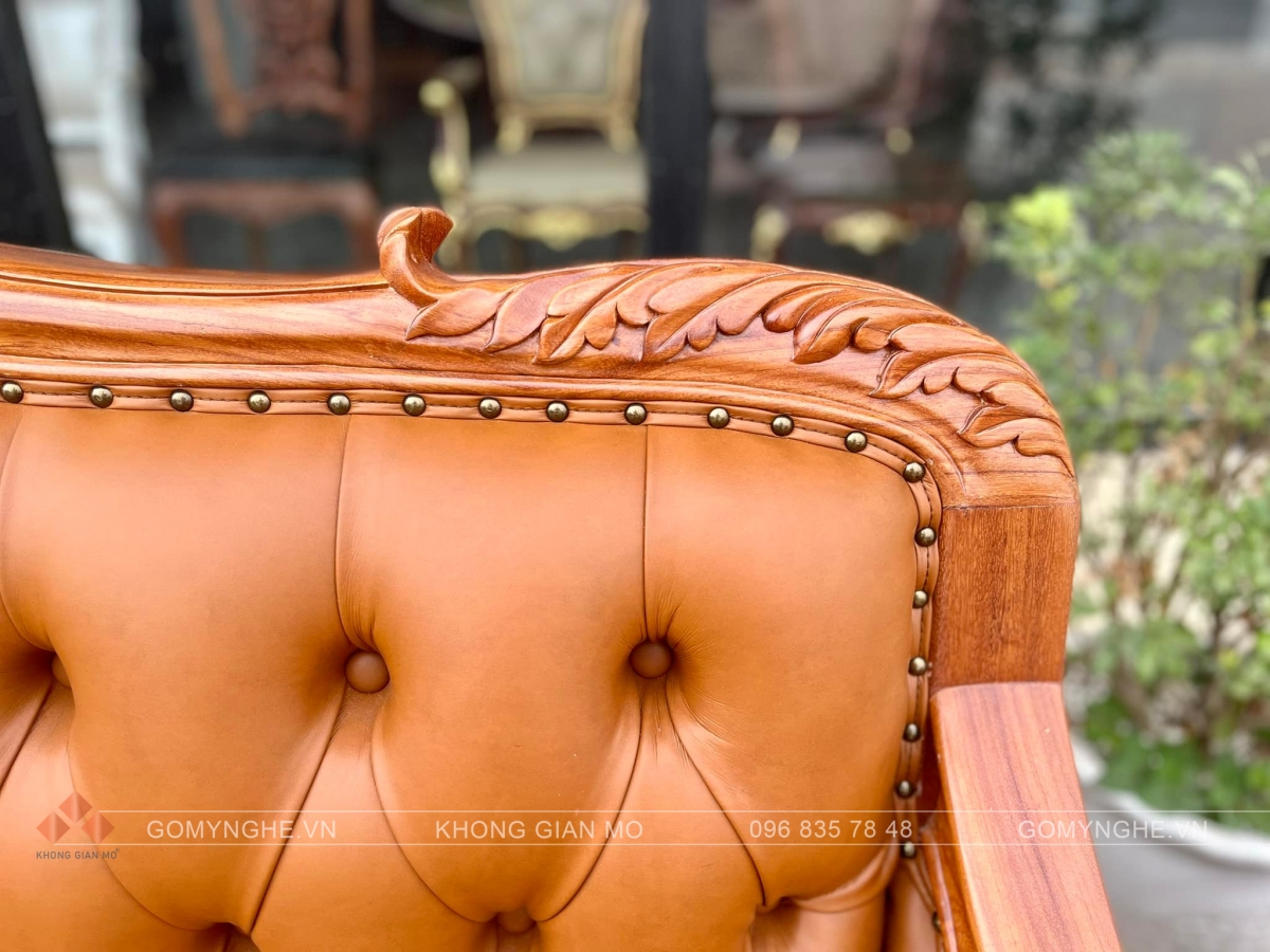 Bộ sofa tân cổ điển gỗ gõ đỏ bọc da Microfiber Pcarola, thiết kế chạm hoa văn đồng bộ, gồm sofa dài, ghế đơn và bàn trà, phù hợp phòng khách sang trọng.