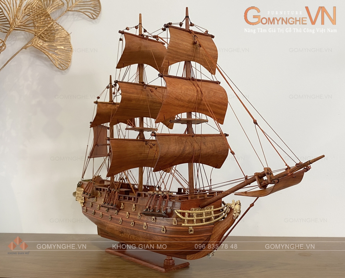 Mô hình thuyền buồm gỗ hương kích thước 40x45x10cm, thiết kế dáng thuyền buồm cổ điển với thân tàu thuôn dài, mũi thuyền vươn cao, hệ thống buồm nhiều tầng và các chi tiết dây chằng được chế tác tỉ mỉ. Sản phẩm thích hợp trang trí bàn làm việc, tủ rượu, kệ decor và làm quà tặng sếp, quà tri ân khách hàng, đối tác tại Gomynghe.